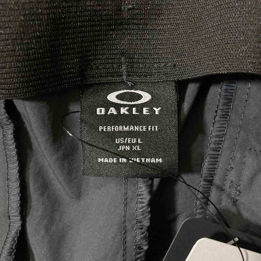 新品未使用タグ付きOAKLEYマットチャコールグレーピステウィンドブレーカーXL